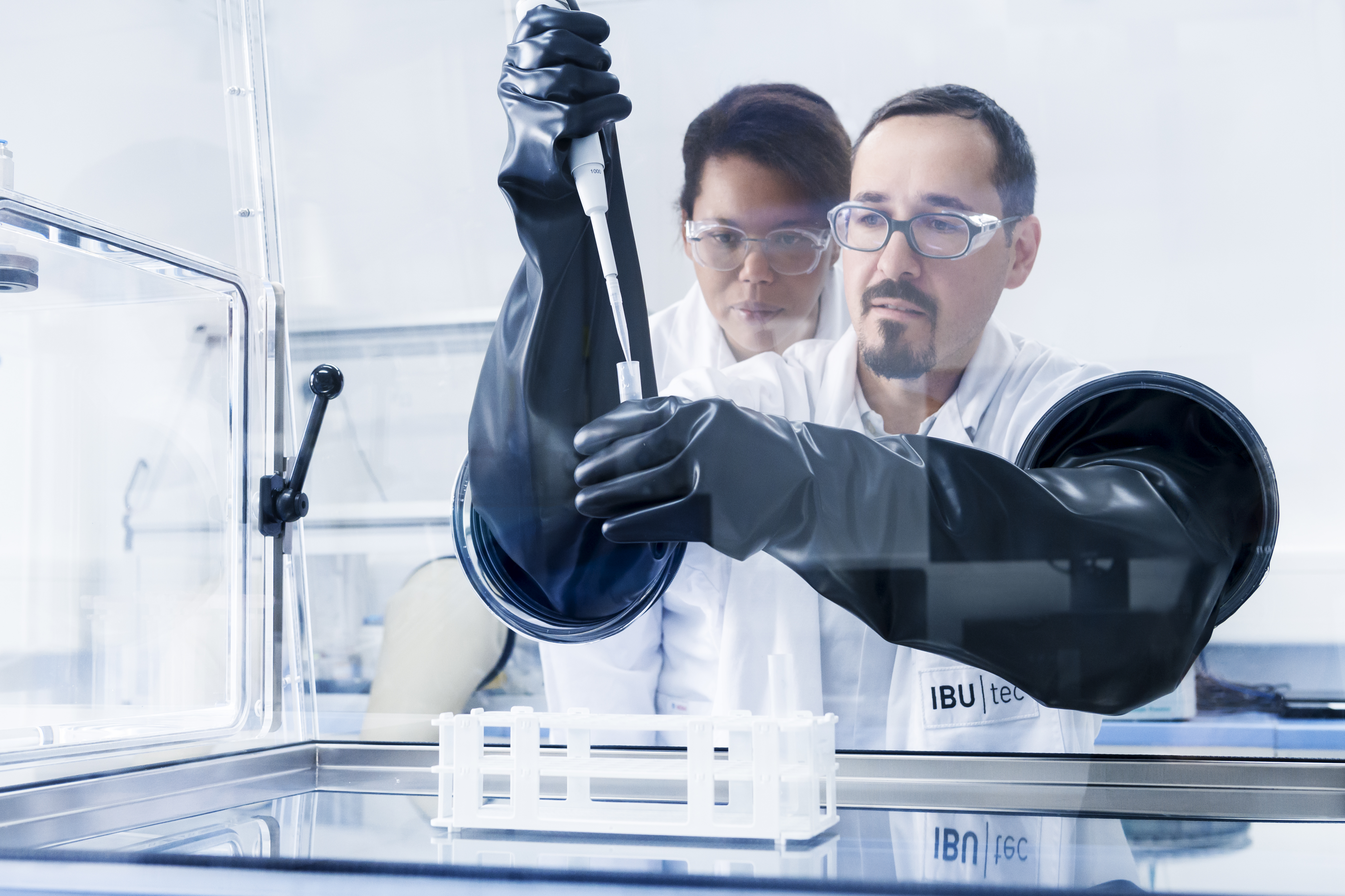 Analyse im Labor mit Laborant und Wissenschaftler an einer Glovebox für Materialentwicklung und Analytik bei IBU-tec Analyse im Labor mit Laborant und Wissenschaftler an einer Glovebox für Materialentwicklung und Analytik bei IBU-tec